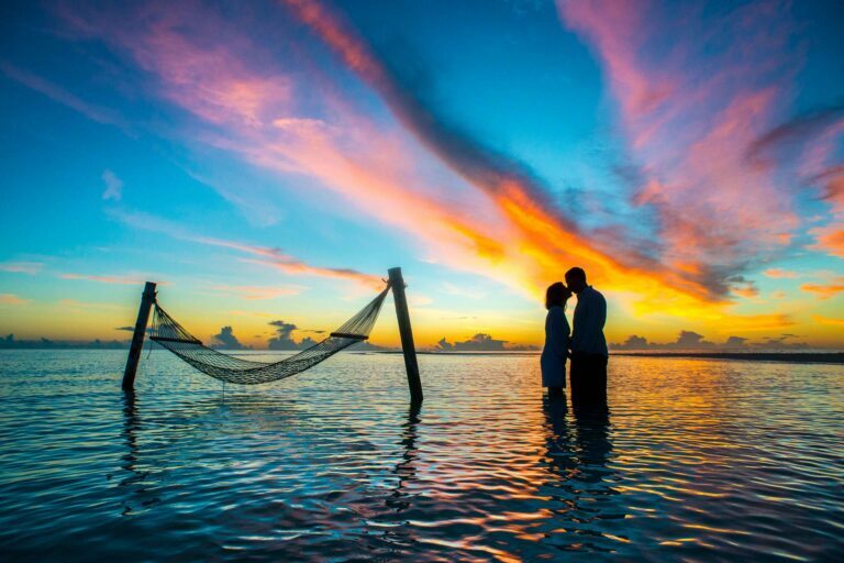 Couples kissing silhouettes on the beach at sunset scaled