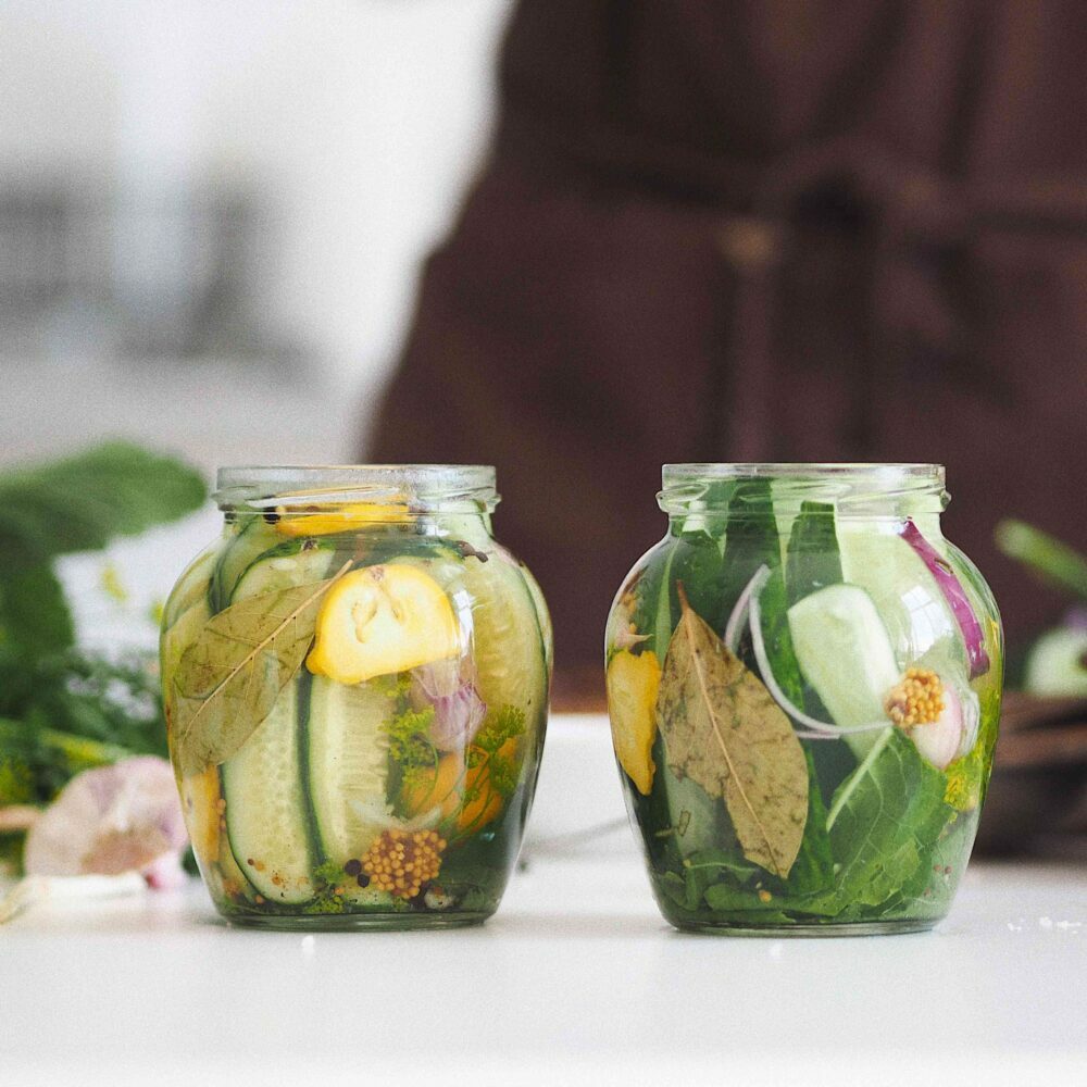 Dill pickles in jars with spices scaled