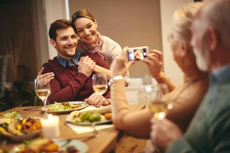 happy elder couple enjoying dinner with son and daughter in law