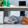A man sleeping with ostrich pillow on the floor