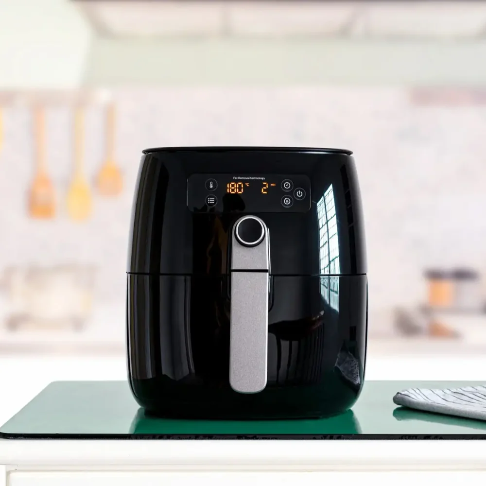 black air fryer machine cooking while placed on top of the table