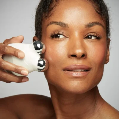 A girl doing facial trimming using facial toner machine