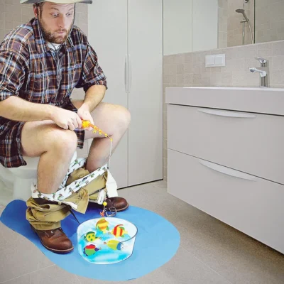 A man playing potty fishing game in the toilet