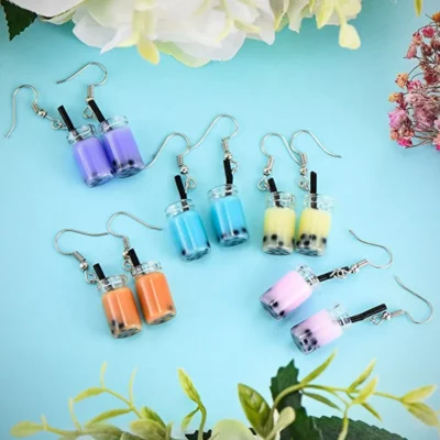 Multi Color Dangle Drop Tea Earrings Kept with Flower Leaves in a blue background for photoshoot 7