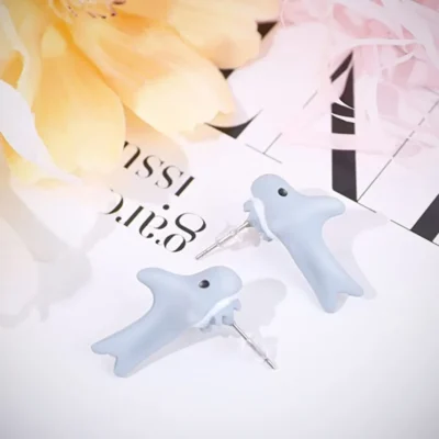 Shark Earrings Kept on the printed paper with flowers in the background 28