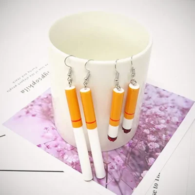 Two Pairs of Cigarette Earring hanged in a white coffee cup on a paper printed the purple flower 23