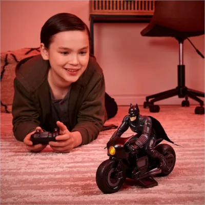 a kid playing with batman riding toy 6