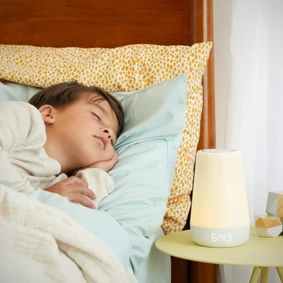 boy sleeps well in the bed with white noise sound machine