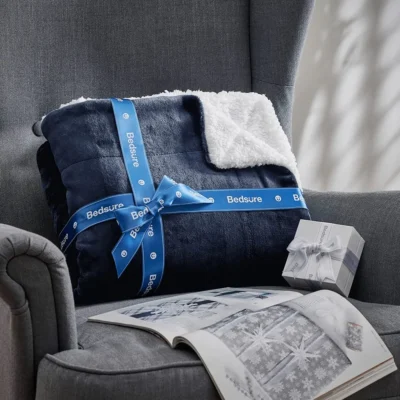 gift wrapped Sherpa fleece blanket kept on the couch for photoshoot besides gift magazine