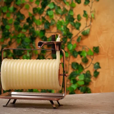 photo of horizontal spiral beeswax candle with the leaves wall background